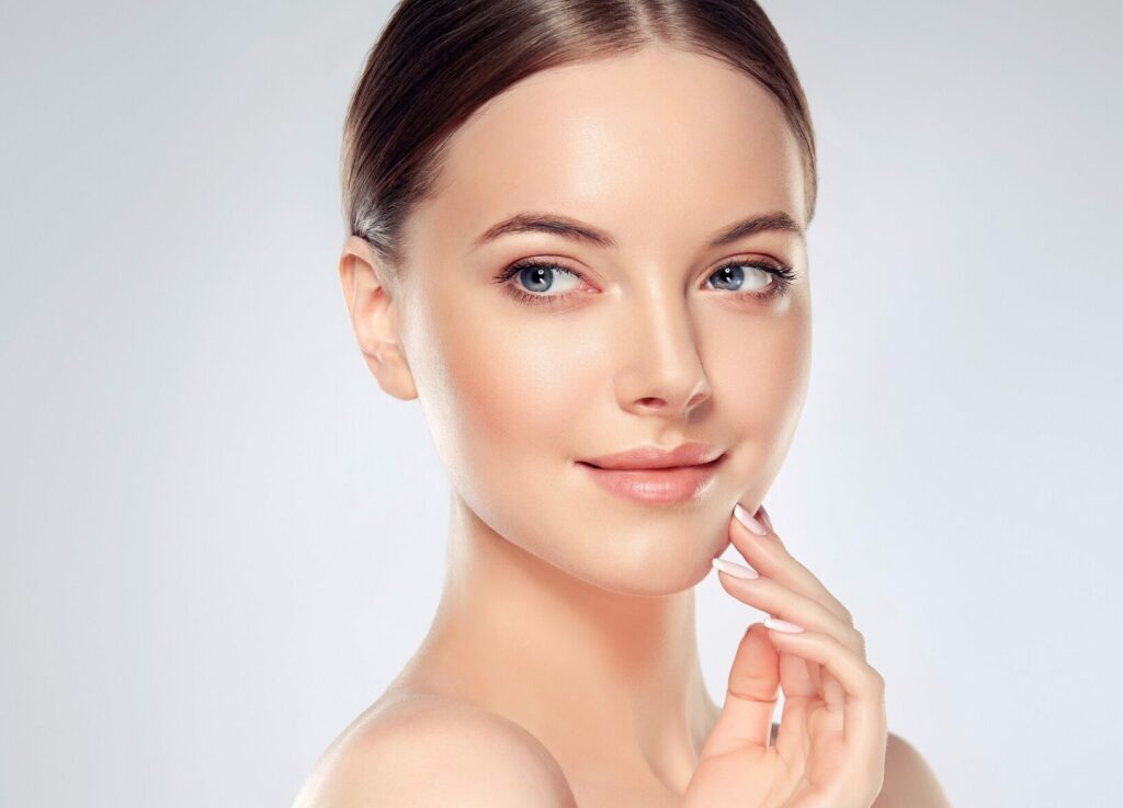 Beautiful young female touching her glowing skin | SpaGo MedSpa in Erie, PA