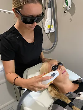 Beautician performing IPL (Intense Pulsed Light) therapy treatment on client | SpaGo MedSpa in Erie, PA